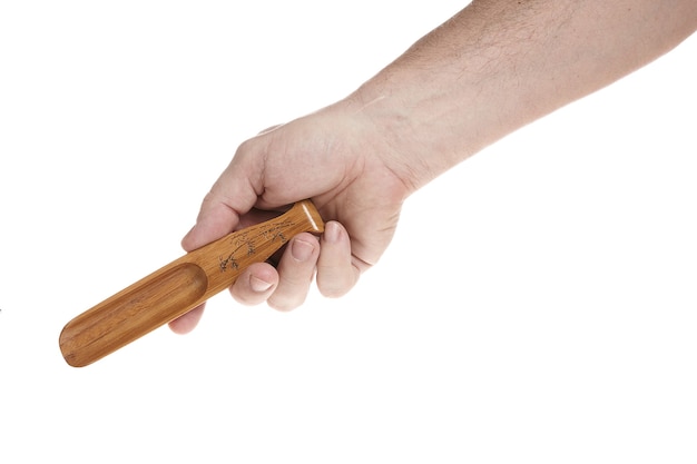 La mano sostiene una pequeña cuchara de madera para cereales sobre un fondo blanco, una plantilla para diseñadores.