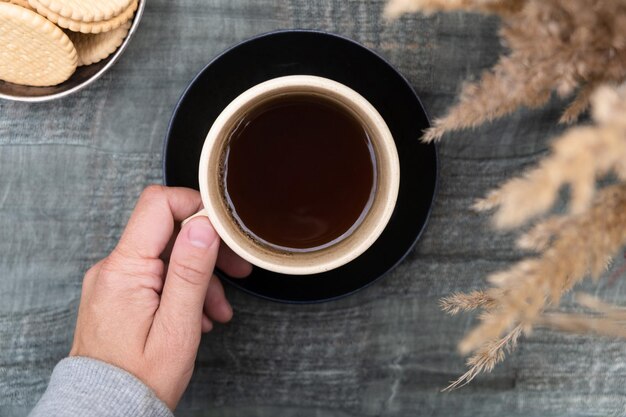 La mano sostiene una taza de café negro bebiendo al aire libre Mantener el estado de ánimo cálido del otoño