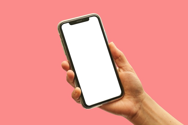 Foto una mano sostiene el teléfono móvil con pantalla vacía sobre fondo rojo.