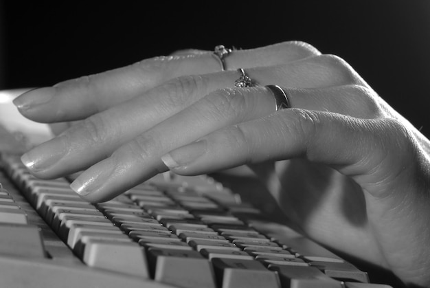 Mano suave de mujer con una manicura en la computadora.