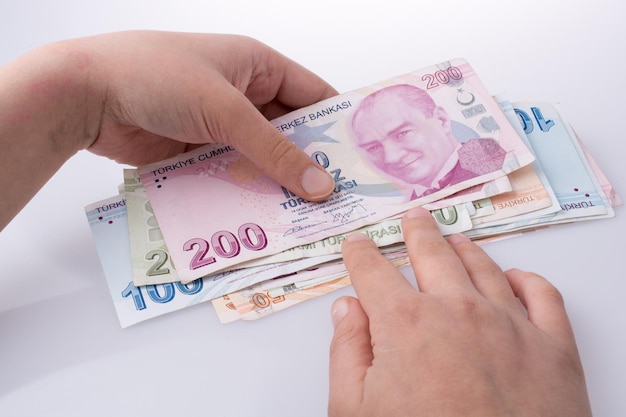 Mano sujetando billetes de Turksh Lira en la mano