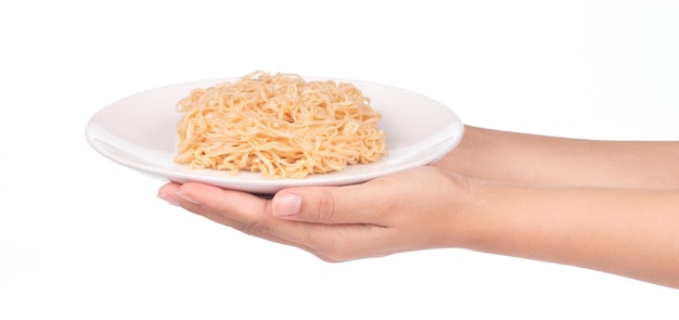 mano sujetando cocidos de fideos instantáneos en plato aislado sobre fondo blanco.