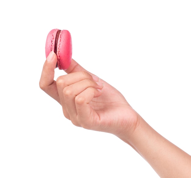 Mano sujetando dulces y coloridos macarons franceses o macaron aislado sobre fondo blanco.