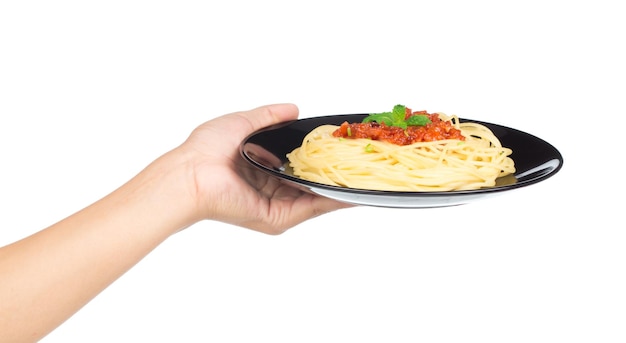 Mano sujetando espaguetis en plato aislado sobre fondo blanco.