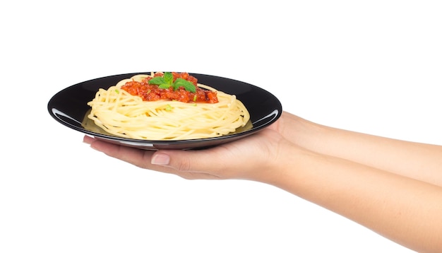 Mano sujetando espaguetis en plato aislado sobre fondo blanco.