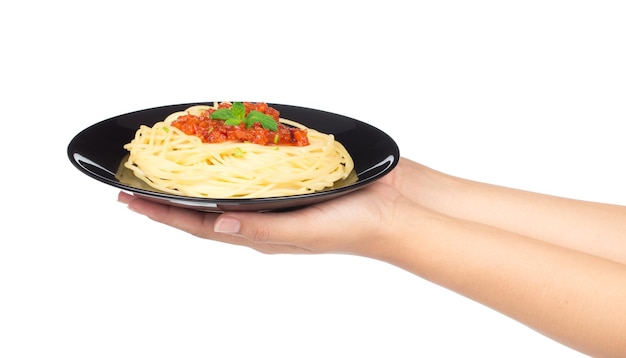 Foto mano sujetando espaguetis en plato aislado sobre fondo blanco.