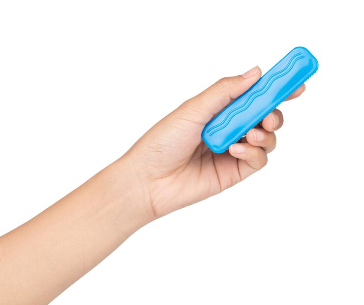 Foto mano sujetando el juguete de la regla de plástico azul aislado en un fondo blanco.