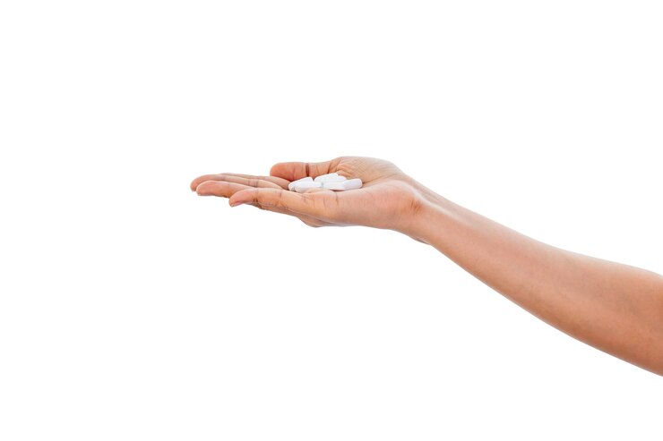 Foto mano sujetando pastillas aislado sobre fondo blanco con trazado de recorte