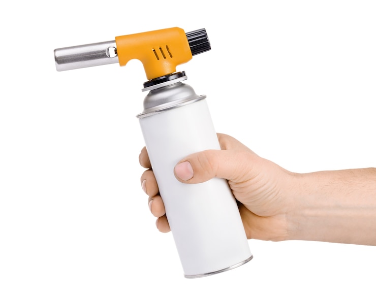 Foto mano sujetando el quemador de antorcha de gas manual aislado en blanco