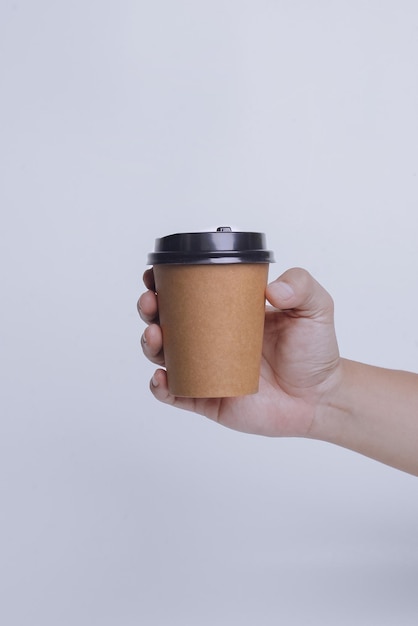 Mano sujetando un vaso de papel aislado sobre fondo blanco Conjunto realista maqueta para plantilla de marca f