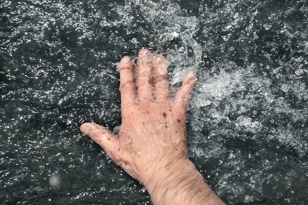 Una mano se sumerge en una corriente de agua Punto de vista
