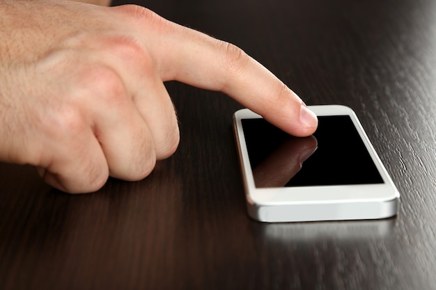 Mano con tablet PC en mesa de madera