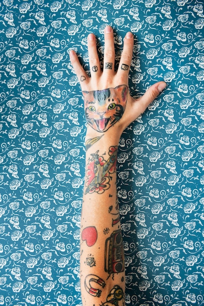 Mano tatuada sobre fondo azul