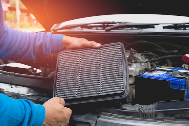 Foto mano del técnico que comprueba el motor del coche. mecánico de automóviles que comprueba el motor de coche.