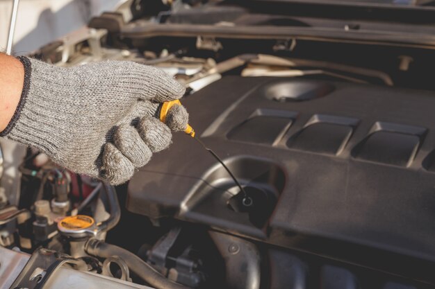 Mano del técnico que comprueba o que fija el motor del coche moderno