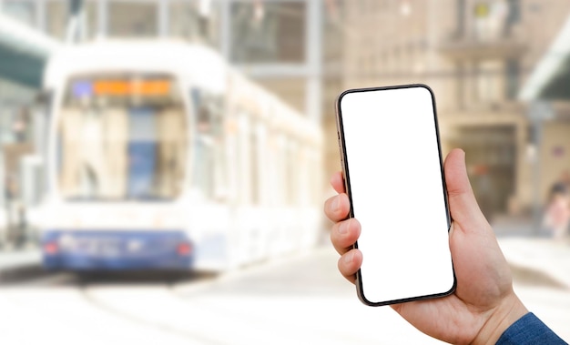 Mano con teléfono en el fondo blanco del autobús urbano. La idea de la aplicación es comprar un billete electrónico para el transporte público, leer un mensaje de texto en un teléfono celular durante un entorno urbano, un camino recortado