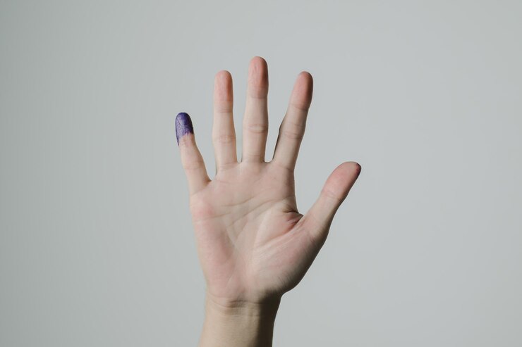 Una mano con tinta púrpura aplicada en el dedo meñique después del pemilu o las elecciones presidenciales indonesias
