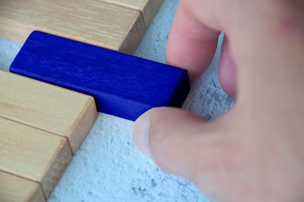 Mano tirando de un bloque de madera azul de otro bloque de madera con espacio personalizable para texto Espacio de copia