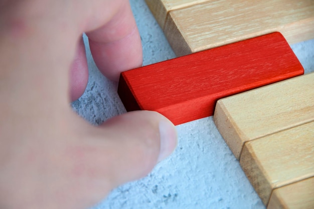 Mano tirando de un bloque de madera rojo de otro bloque de madera con espacio personalizable para texto Espacio de copia