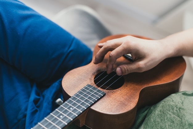 Mano tocando una pequeña guitarra