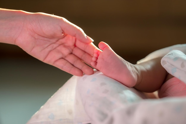 Mano tocando el pie del bebé recién nacido con amor