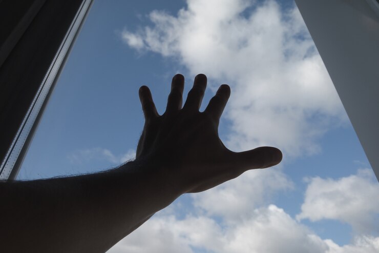 Foto una mano tocó el cristal de la ventana. el cielo de fondo