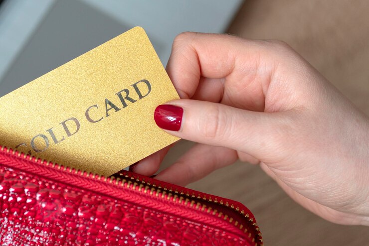 Mano toma una tarjeta de una billetera billetera para tarjeta de computadora portátil con una tarjeta dorada