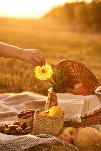 Mano tomar chips de frutas de la canasta.