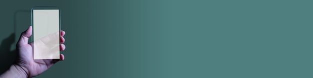 Mano usando una computadora de teléfono inteligente en blanco sobre fondo verde pastel
