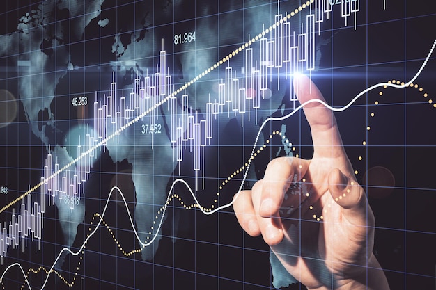 Mano usando gráfico de velas con holograma de mapa del mundo digital