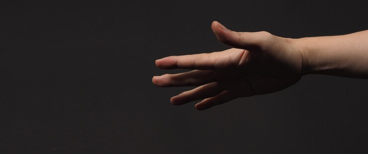 Foto mano vacía muestra cinco dedos con sombra negra aislada sobre fondo negro
