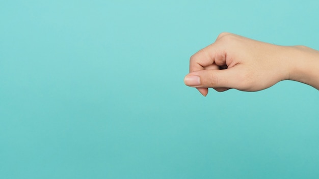 Foto mano vacía sosteniendo o atrapando nada guesture sobre fondo verde o azul tiffany o menta.