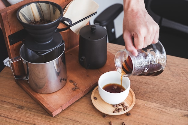 Una mano vertiendo café por goteo en una taza