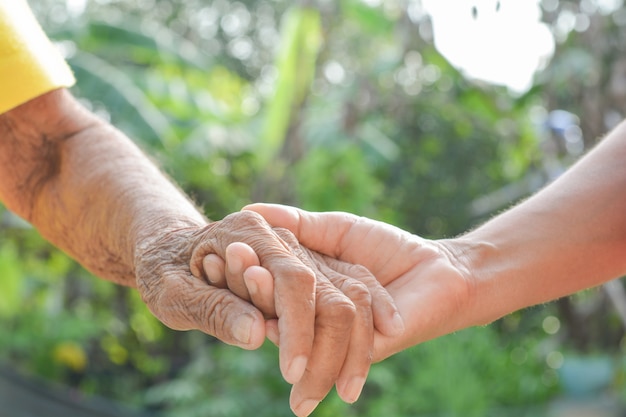 Mano, viejo y mano con luz de la mañana