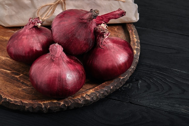 Manojo de cebolla orgánica roja granja eco verduras mesa oscura