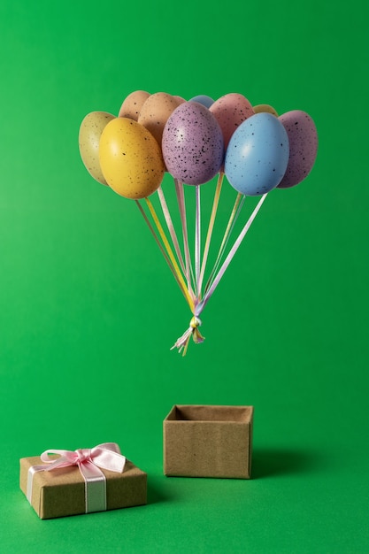 Foto manojo colorido de globos de huevos de pascua con caja de regalo en verde.