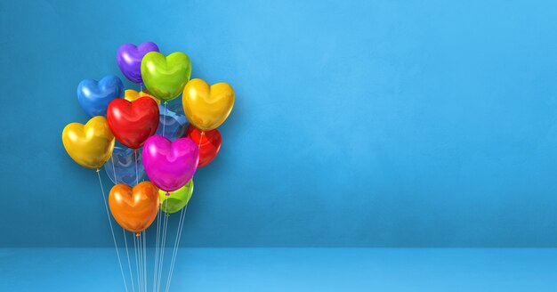 Manojo de globos de forma de corazón colorido sobre un fondo de pared azul. Banner horizontal. Ilustración 3D render