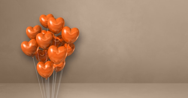 Manojo de globos con forma de corazón naranja sobre una pared beige