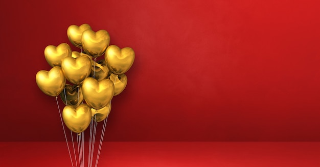 Manojo de globos con forma de corazón de oro sobre una superficie roja