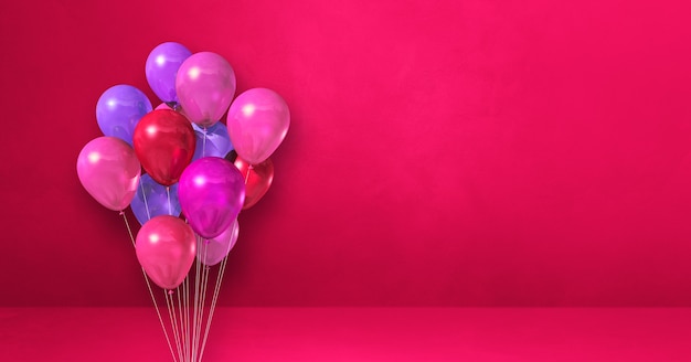 Manojo de globos sobre una superficie rosa