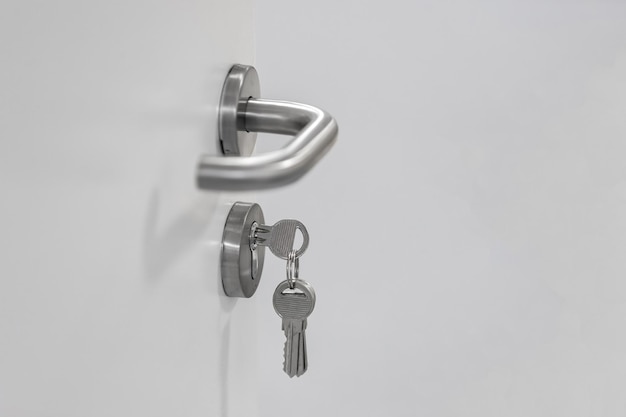 Un manojo de llaves insertadas en la cerradura de una puerta con manija