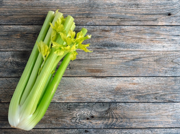 Manojo de tallo de apio fresco con hojas sobre fondo de madera rústica Apio nabo orgánico Concepto de dieta de alimentos saludables y vegetarianos Ramita de apio crudo