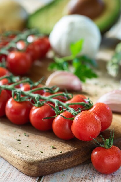Foto manojo de tomates cherry en un tablero con ingredientes