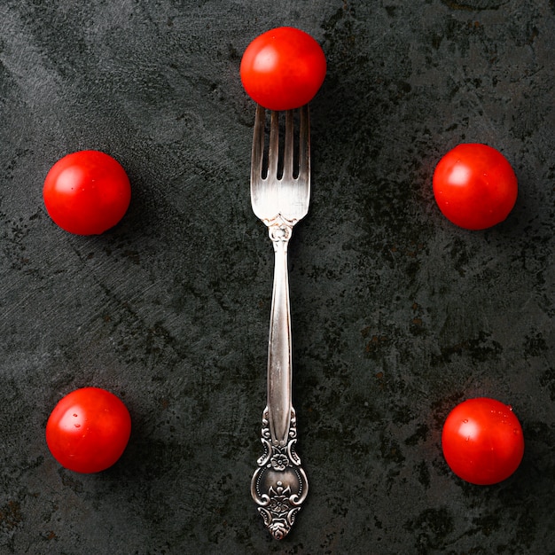 Un manojo de tomates cherry con tomate en un tenedor