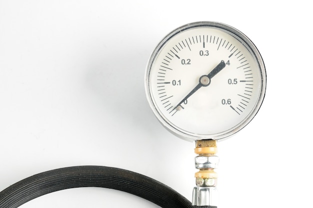 Manômetro para medir a pressão do ar em close-up de pneus de automóveis em um branco isolado