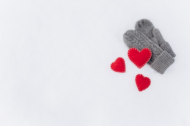 Unas manoplas y corazones rojos decorativos para el Día de San Valentín.