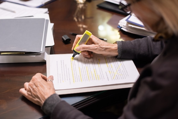 Foto manos de abogada contemporánea destacando líneas de contrato