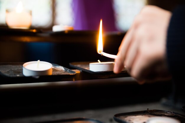 Foto manos afinando velas en una iglesia