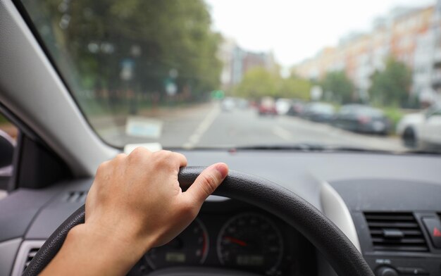 Foto las manos agarran el volante de un automóvil que simboliza la conducción segura y controlada, centrándose en la responsabilidad