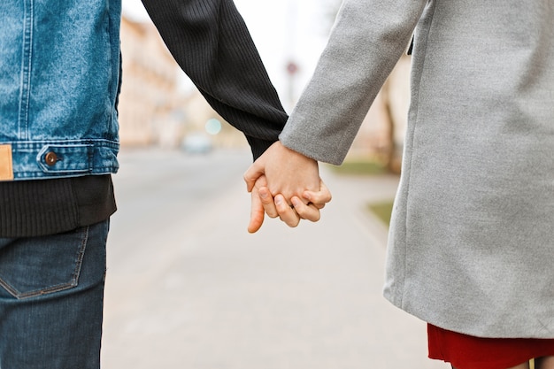 Manos de amantes. Pareja caminando en la ciudad cogidos de la mano.